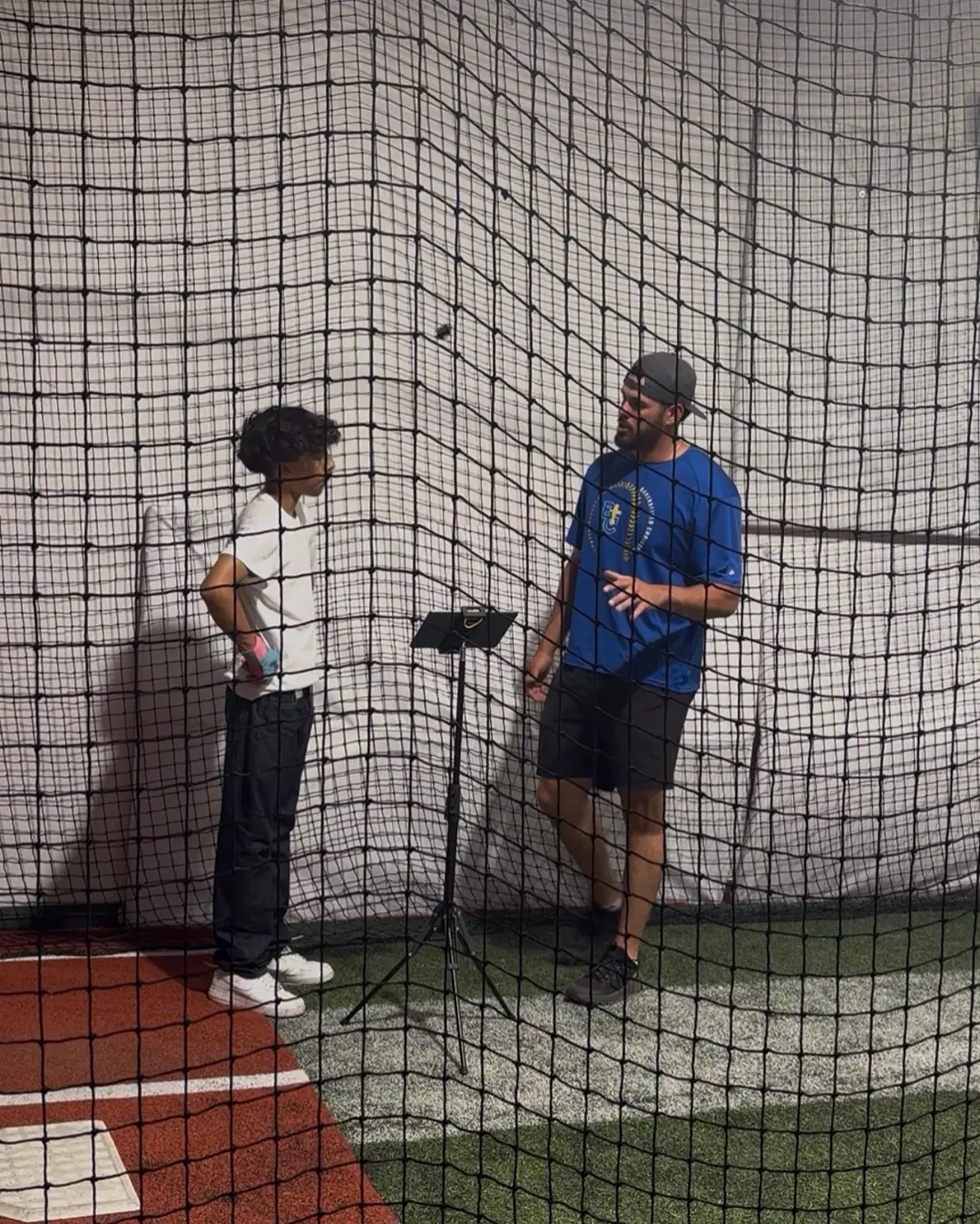 A coach talking through a session plan with a young hitter at The Lab