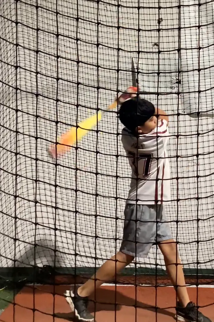 A middle school hitter mid-swing at The Lab