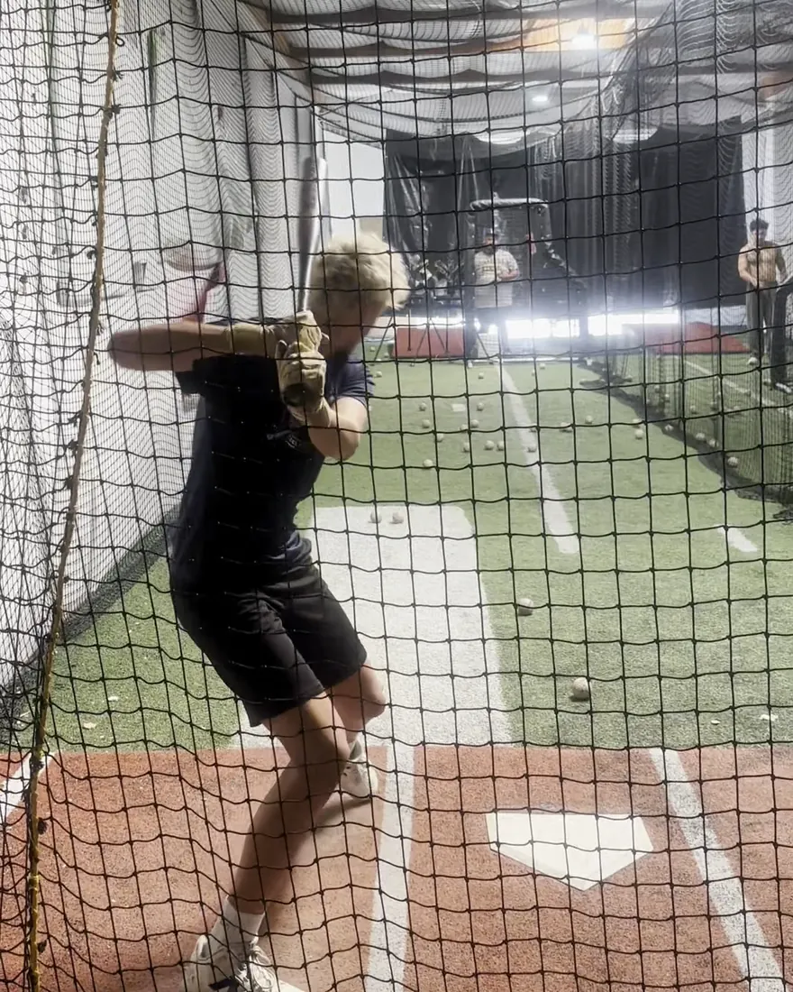 A high school hitter loading in the cage at The Lab